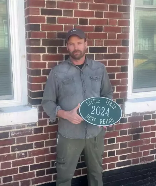 man holding little italy sign