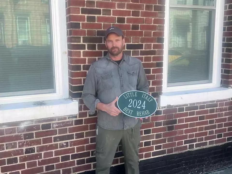man holding little italy sign